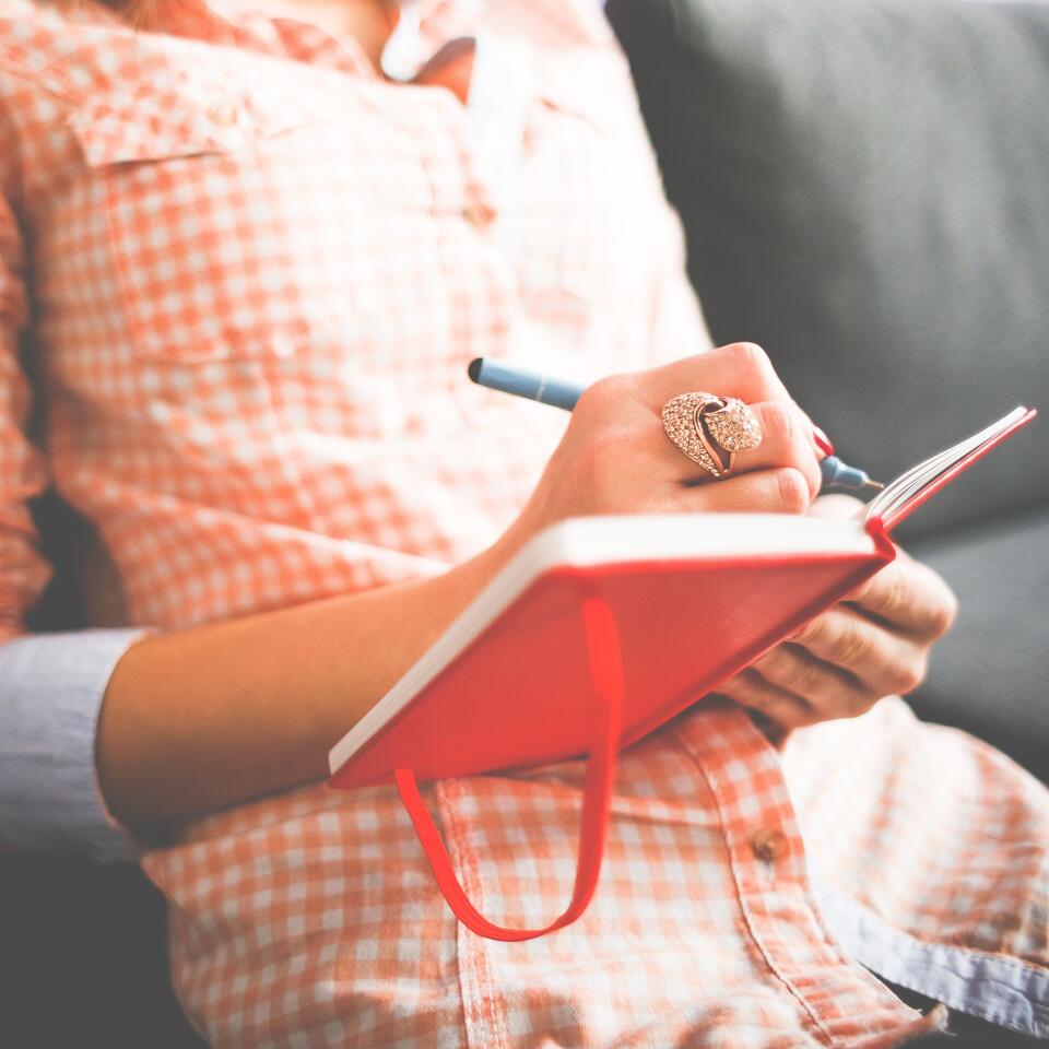 #träume. Eine Frau schreibt in einem Tagebuch.